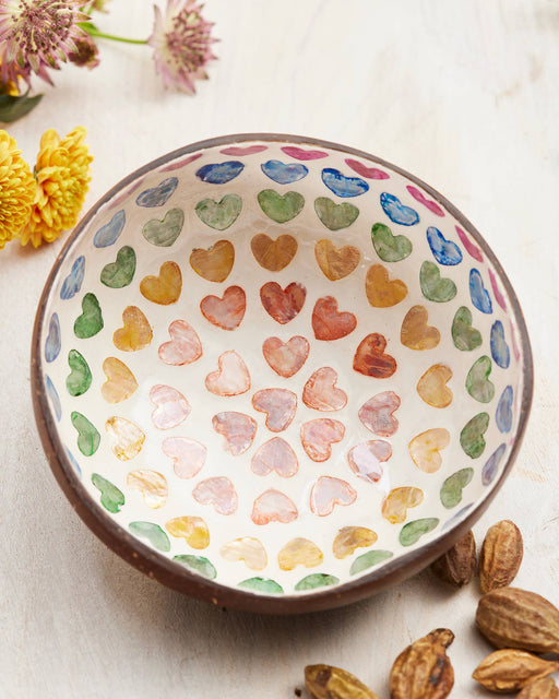 Decorative coconut bowl with a heart pattern on a light background