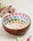 Coconut bowl with colourful heart patterns on a light background