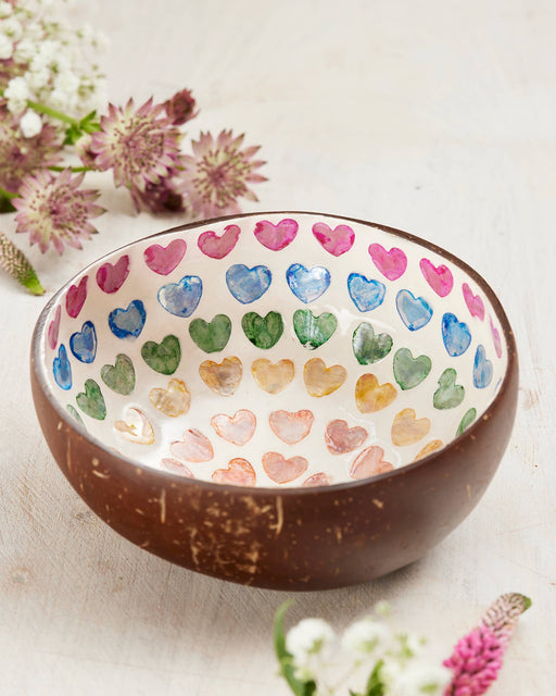 Coconut bowl with colourful heart patterns on a light background