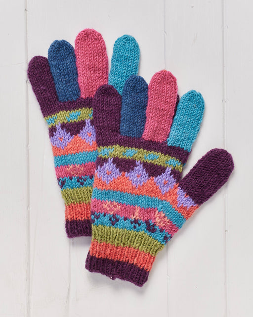 A pair of hand knitted Shivalaya Finger Gloves on a white wooden surface