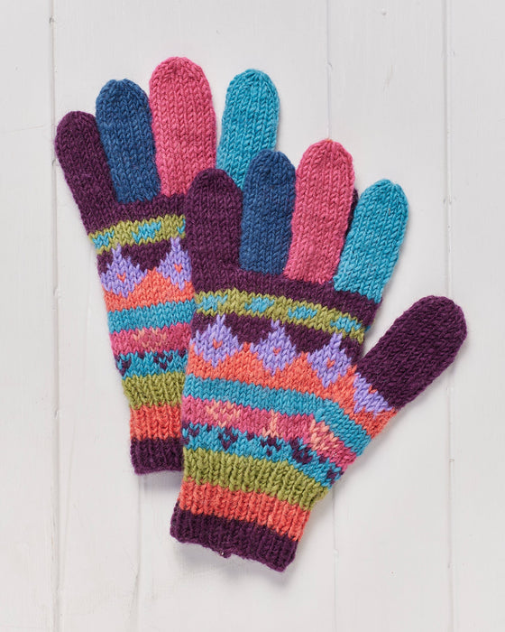 A pair of hand knitted Shivalaya Finger Gloves on a white wooden surface