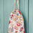 Colorful floral drawstring bag on a teal wooden background