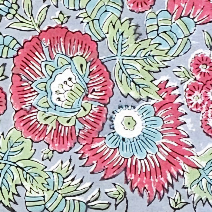 Detailed image of the Handcrafted 100% cotton tablecloth in Slate Garden print, showing crimson red flowers, sage green leaves on a blue-grey background.