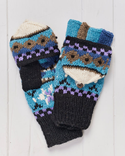 A pair of hand knitted Snowflake Hunter Gloves on a whitewashed wooden background.