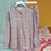 Floral pajama set on a hanger against a colorful background