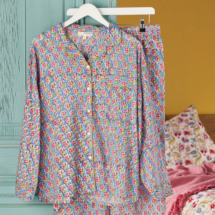 Floral pajama set on a hanger against a colorful background
