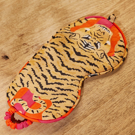 Tiger-patterned eye mask on a wooden surface