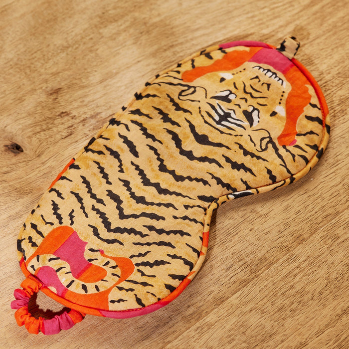 Tiger-patterned eye mask on a wooden surface
