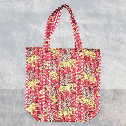 Red leopard tote bag set against a textured grey background