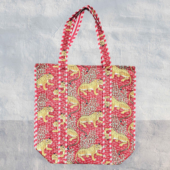 Red leopard tote bag set against a textured grey background